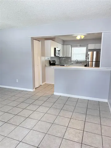 a view of kitchen with granite countertop cabinets and window