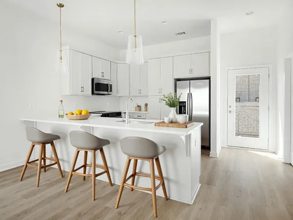 a kitchen with stainless steel appliances granite countertop a stove top oven a refrigerator a sink and a dining table with wooden floor