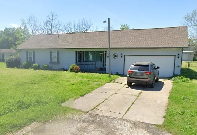 a view of a house with a yard and garage