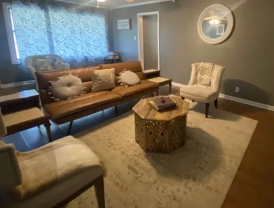 a living room with furniture and a wooden floor