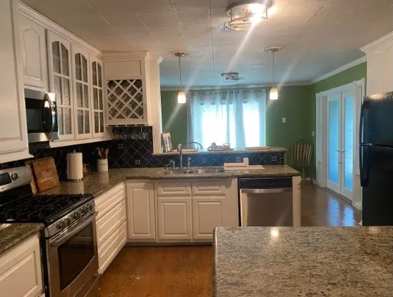 a kitchen with stainless steel appliances granite countertop a stove a sink and a refrigerator