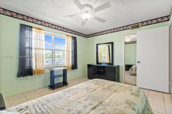 a bedroom with a bed and a dresser next to a window