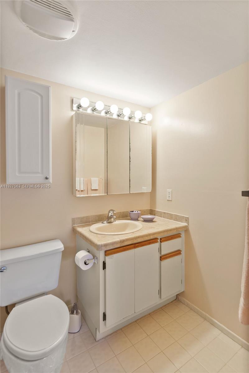 190 Southeast 5th Avenue, Unit 202 Dania Beach, FL 33004 - Photo 28 of 36 a bathroom with a toilet sink and mirror