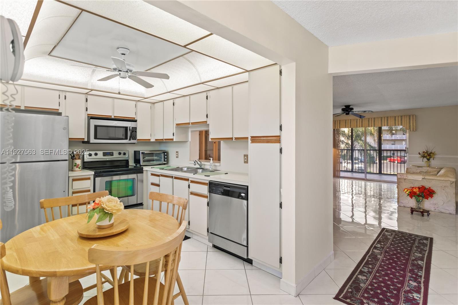 190 Southeast 5th Avenue, Unit 202 Dania Beach, FL 33004 - Photo 29 of 36 a kitchen with stainless steel appliances granite countertop a stove a refrigerator a sink dishwasher a dining table and chairs with wooden floor