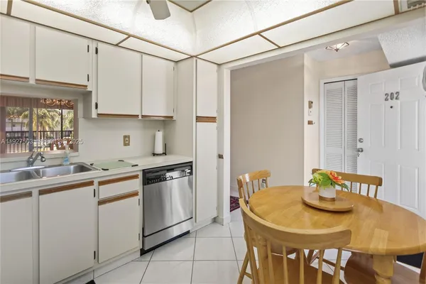 a kitchen with stainless steel appliances granite countertop a sink a stove a refrigerator with a dining table and chairs