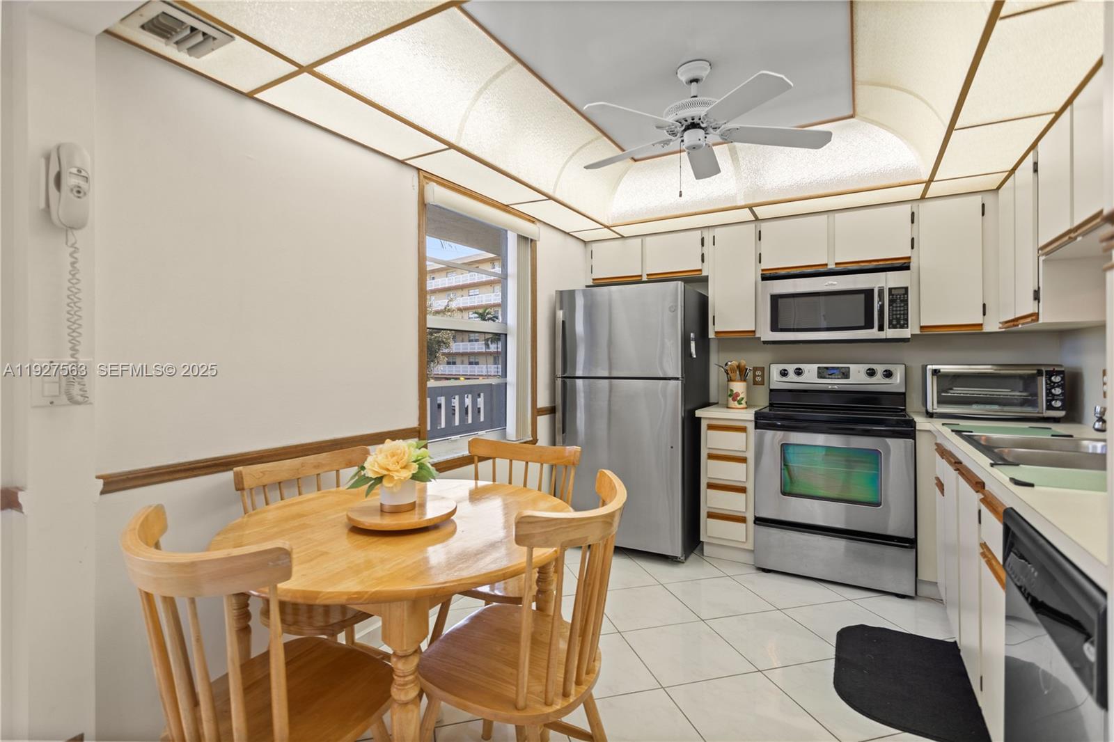 190 Southeast 5th Avenue, Unit 202 Dania Beach, FL 33004 - Photo 4 of 36 a kitchen with stainless steel appliances granite countertop a refrigerator a stove a sink dishwasher a dining table and chairs with wooden floor