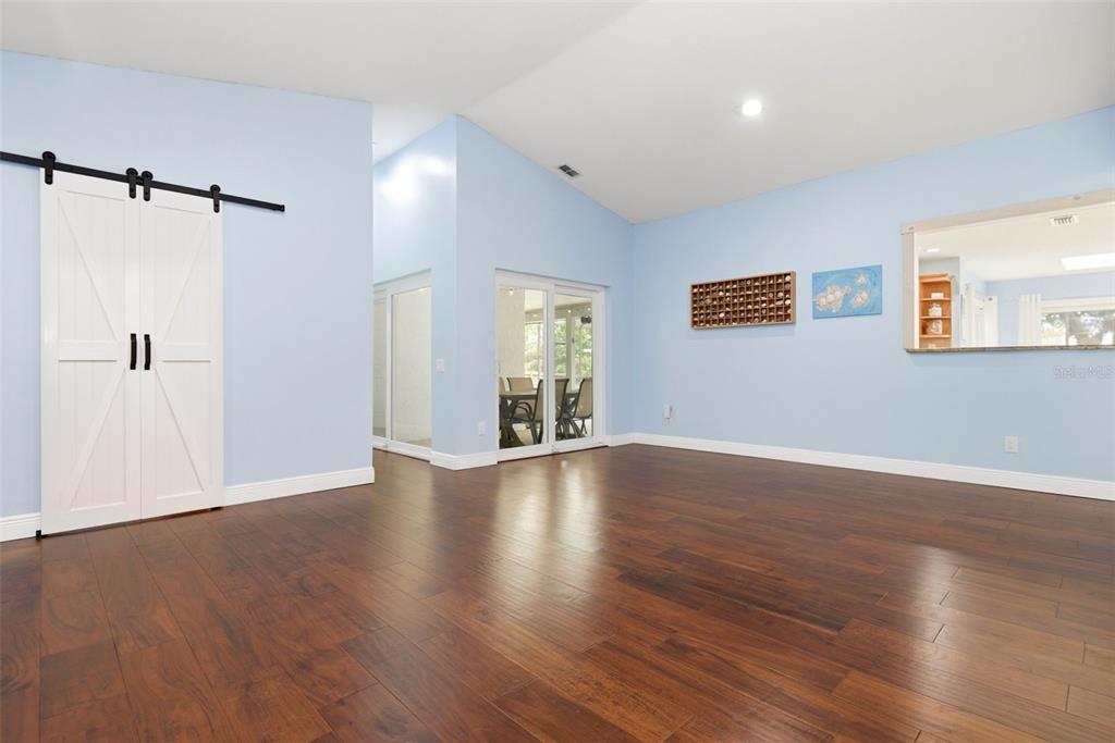 7432 Sparkling Lake Road Orlando, FL 32819 - Photo 7 of 54 a view of an empty room with wooden floor and a window