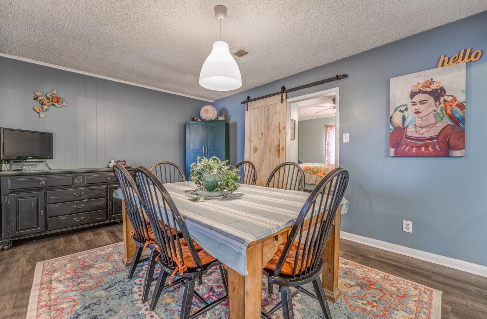 4660 Vincent Road Millington, TN 38053 - Photo 17 of 37 Dining room featuring a textured ceiling, a barn door, dark wood-type flooring, visible vents, and baseboards