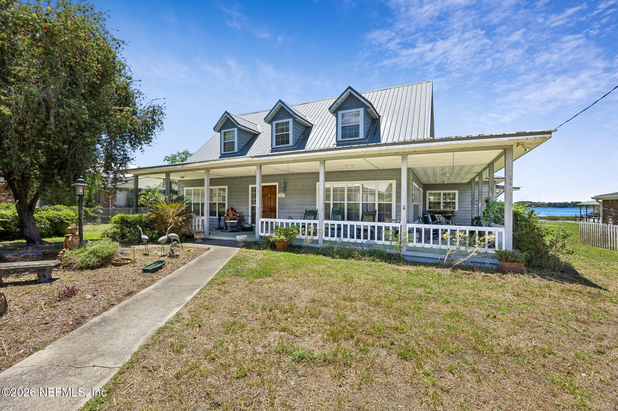 7430 Southwest County Road 18 Hampton, FL 32044 - Photo 5 of 72 a view of a white house with large windows and a yard