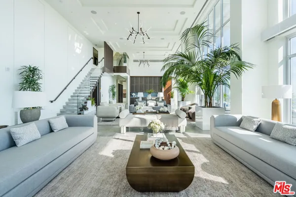 a living room with furniture and a chandelier