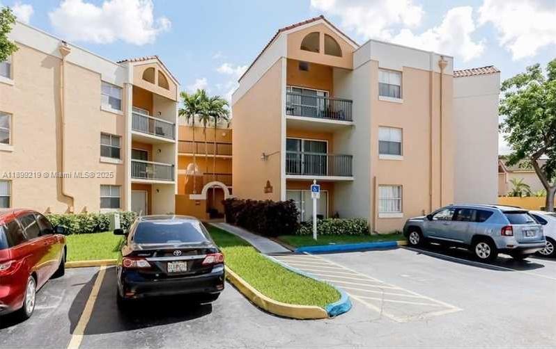 6280 Northwest 186th Street, Unit 311 Hialeah, FL 33015 - Photo 16 of 19 a view of a cars park in front of a building