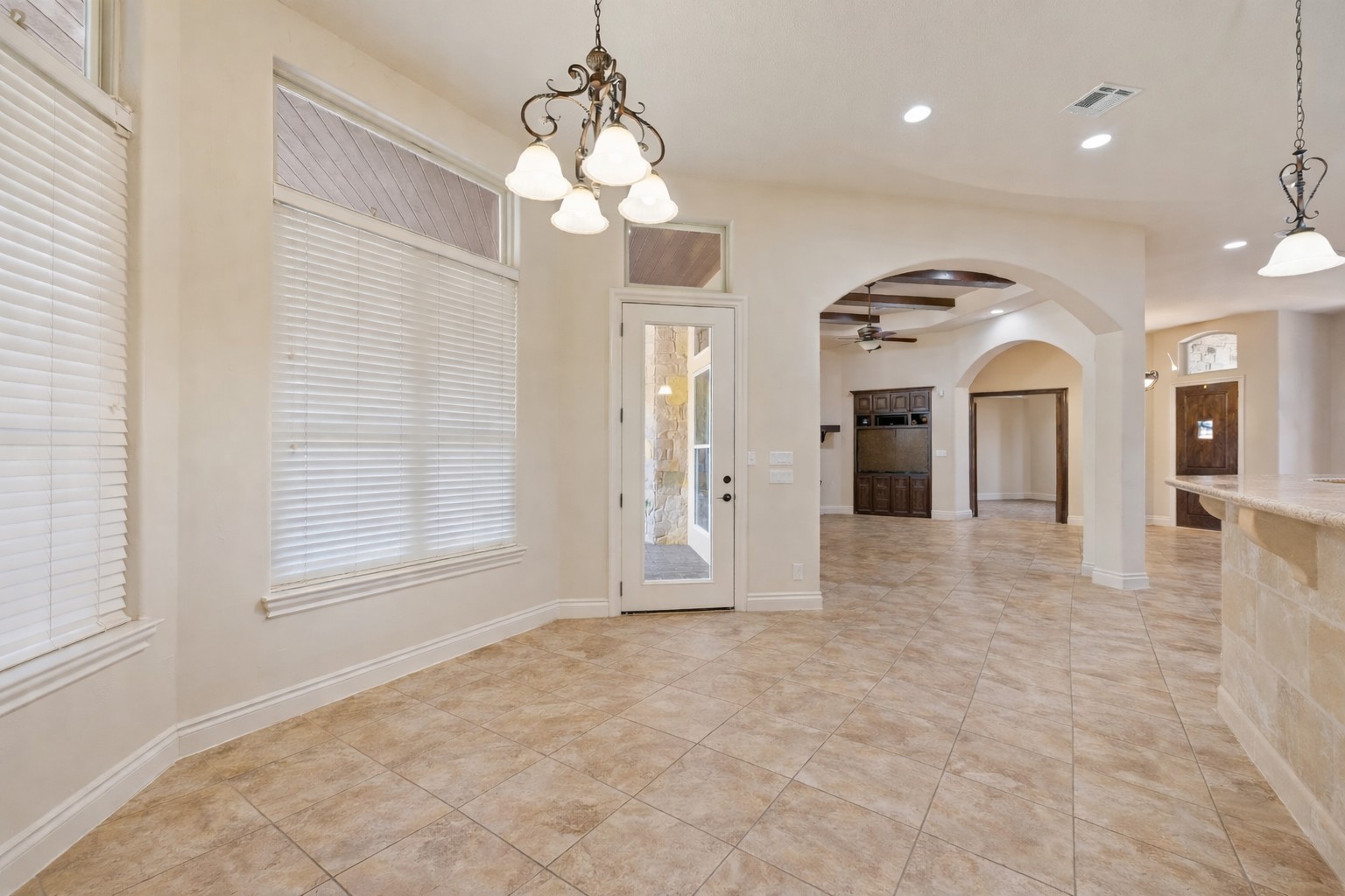 109 Ranchers Club Lane Driftwood, TX 78619 - Photo 10 of 19 Eat in dining area featuring arched walkways, a chandelier, recessed lighting, ceiling fan, and light tile patterned floors