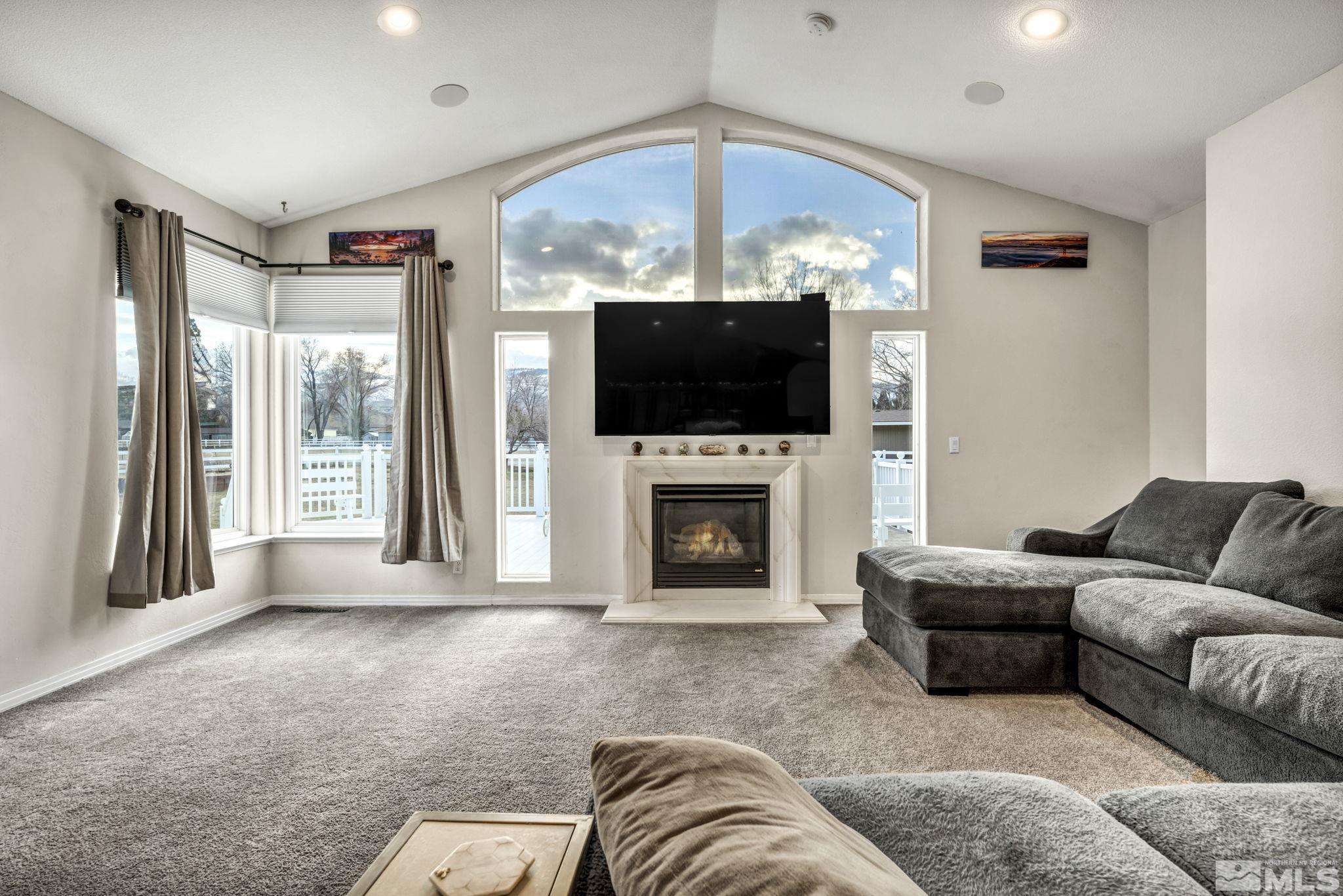 9811 Dixon Lane Reno, NV 89511 - Photo 12 of 40 a living room with furniture a fireplace and a flat screen tv