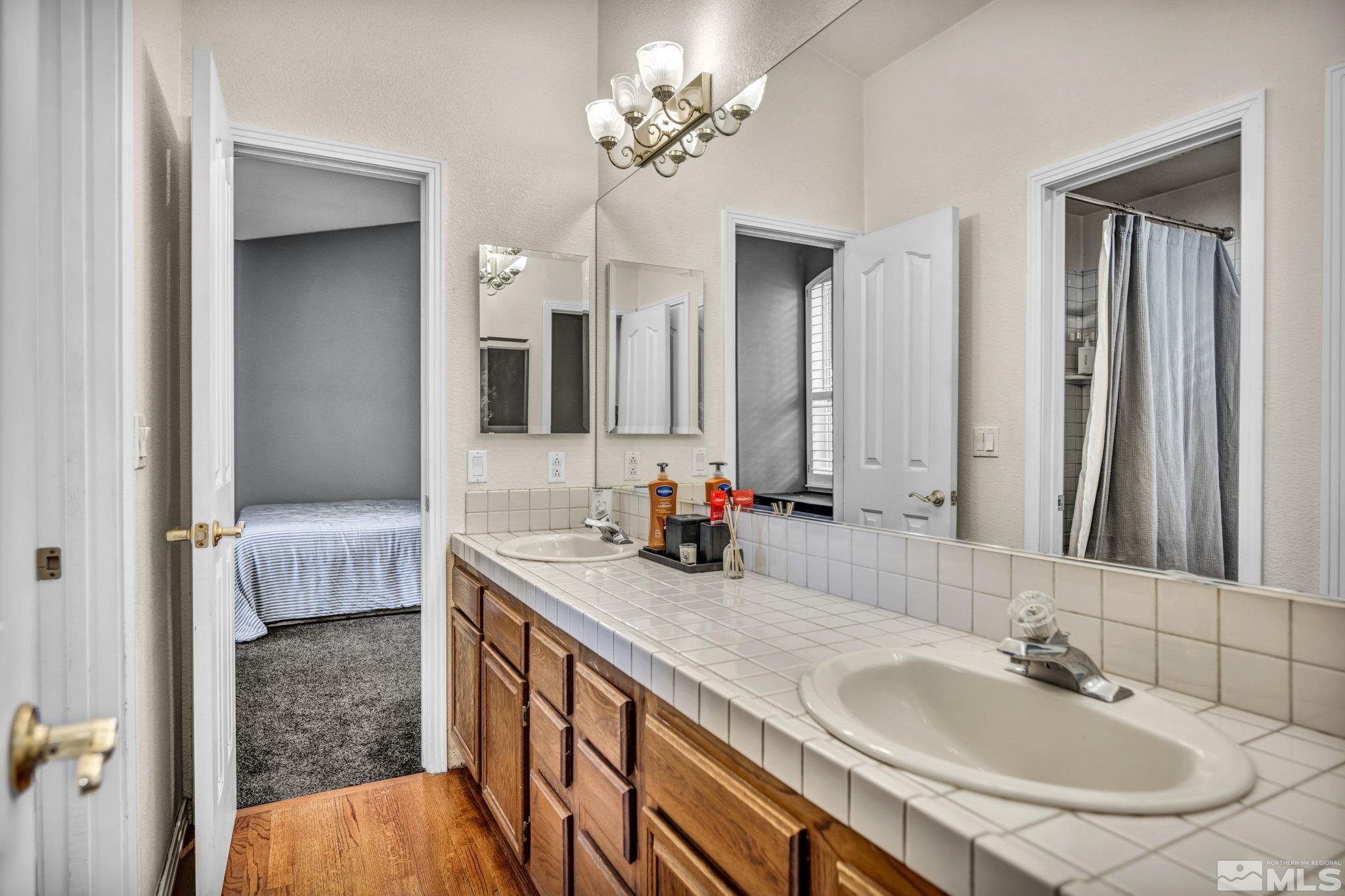 9811 Dixon Lane Reno, NV 89511 - Photo 21 of 40 a en suite bathroom with a double sink double vanity and a mirror