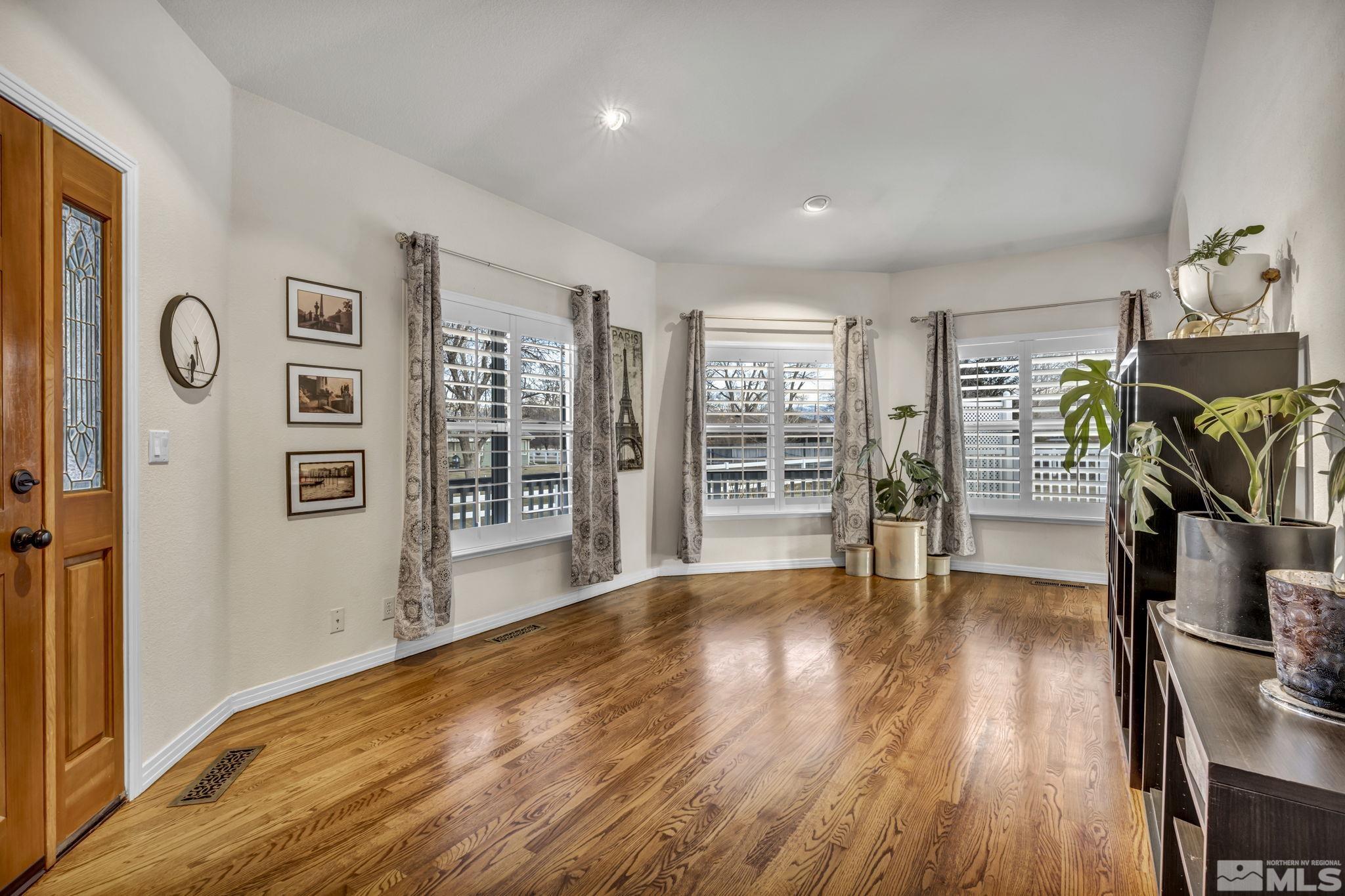 9811 Dixon Lane Reno, NV 89511 - Photo 7 of 40 a view of empty room with wooden floor and fan