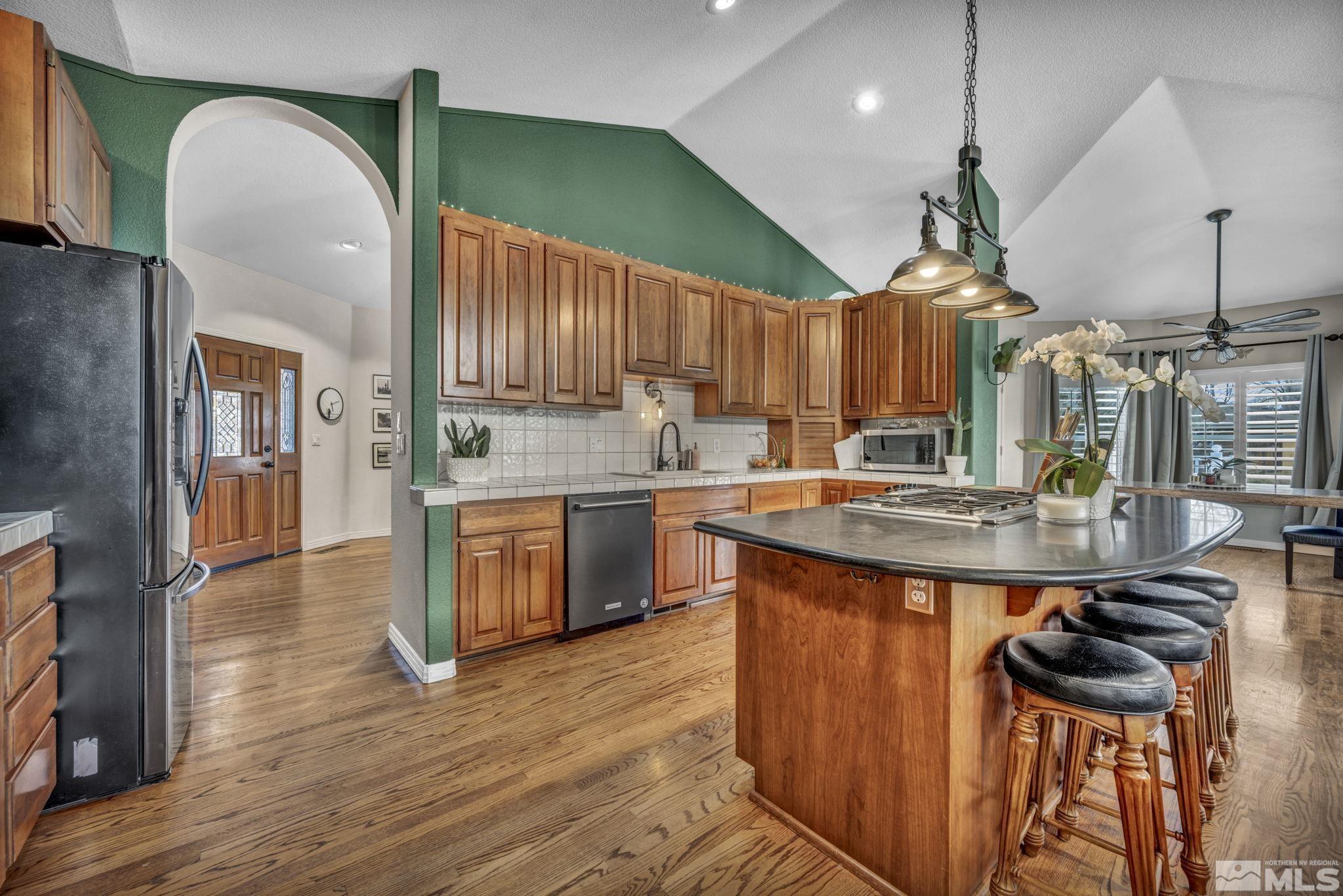 9811 Dixon Lane Reno, NV 89511 - Photo 8 of 40 a kitchen with stainless steel appliances granite countertop a sink a stove and a wooden floors