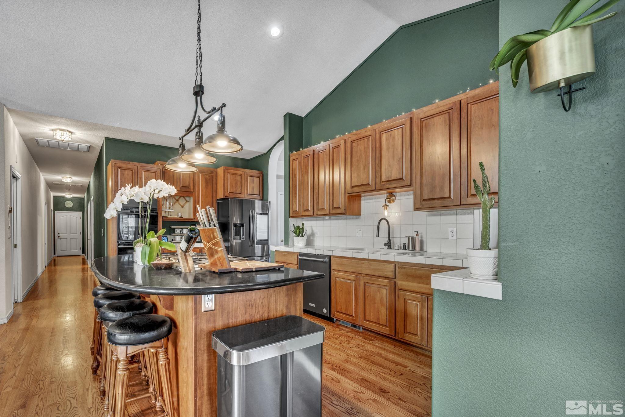 9811 Dixon Lane Reno, NV 89511 - Photo 9 of 40 a kitchen with stainless steel appliances granite countertop a sink a stove and a wooden floors