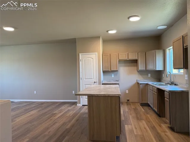 a view of a kitchen with a sink cabinets and wooden floor