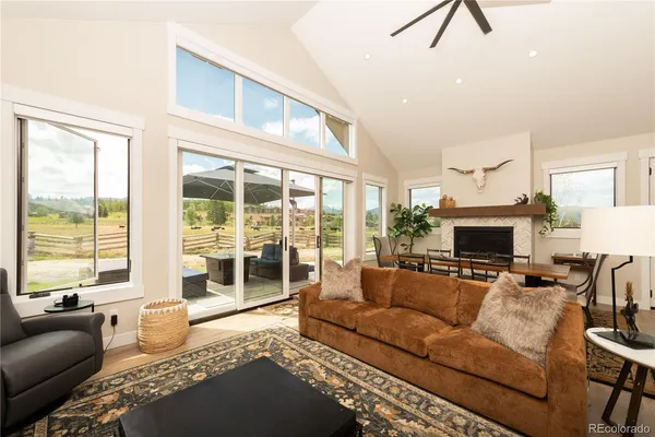a living room with furniture large window and a fireplace