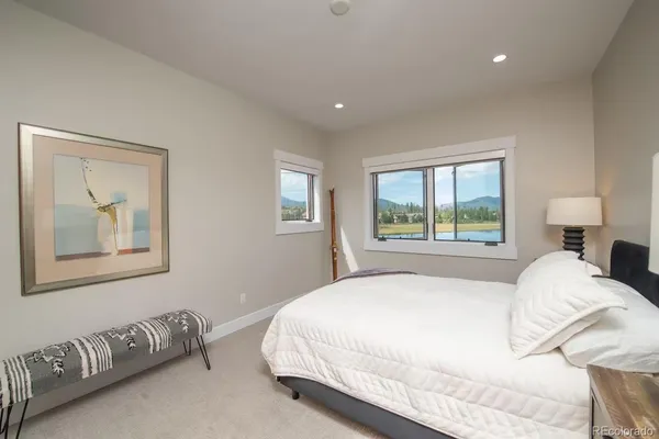 a large bed sitting in a bedroom next to a window