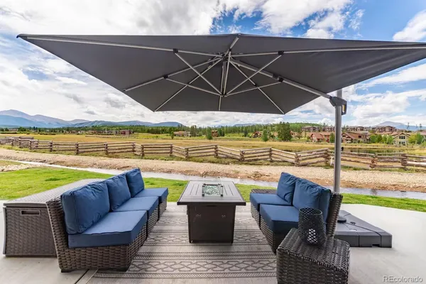 an outdoor sitting area with furniture and umbrella