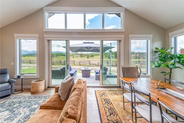a living room with furniture and floor to ceiling windows