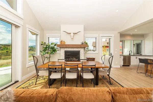 a dining room with furniture a fireplace and wooden floor