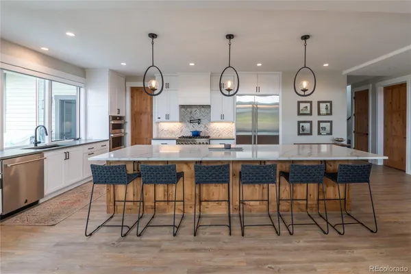 a dining room with wooden floor a chandelier a wooden table and chairs