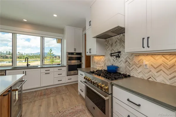 a kitchen with stainless steel appliances granite countertop a stove and a sink