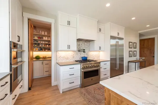 a kitchen with stainless steel appliances kitchen island granite countertop a refrigerator stove and oven