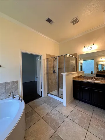 a large bathroom with a granite countertop tub shower and sink