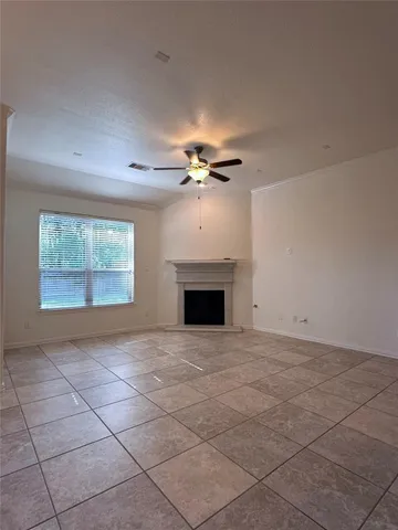 a view of an empty room with a fireplace and a window