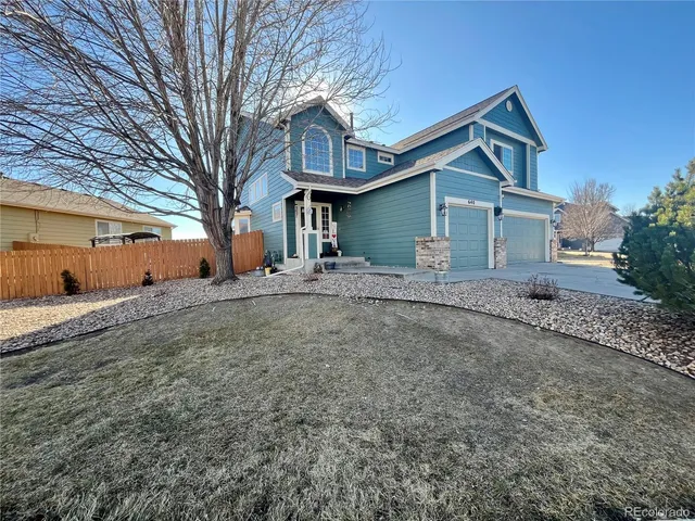 a front view of a house with large trees