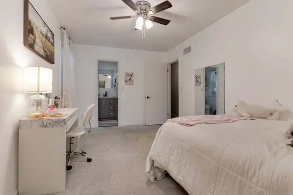 a view of a hallway with wooden floor and a bathroom