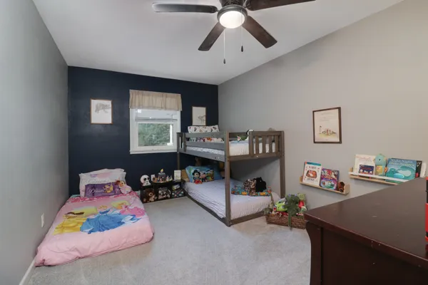 a bedroom with a bed couch and a flat tv screen