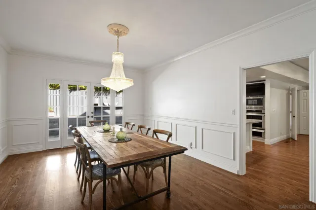 a dining room with furniture a chandelier and wooden floor