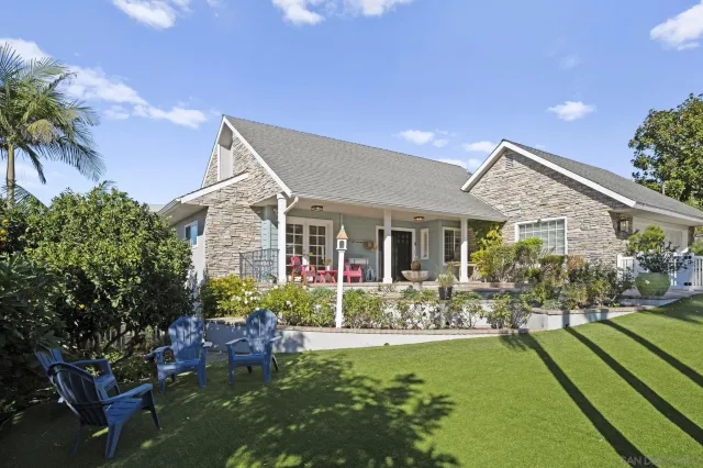 a view of a house with large windows and plants