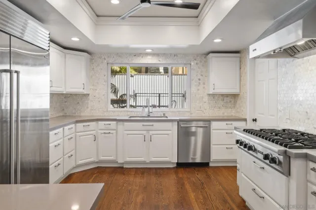 a kitchen with granite countertop a sink stainless steel appliances and cabinets