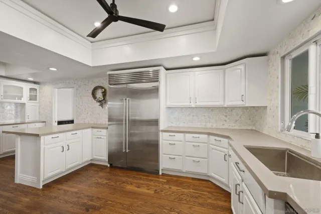 a kitchen with white cabinets and appliances