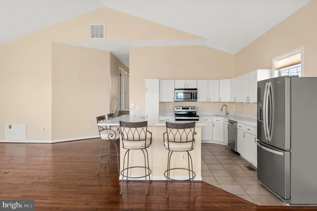 a kitchen with a refrigerator cabinets and wooden floor