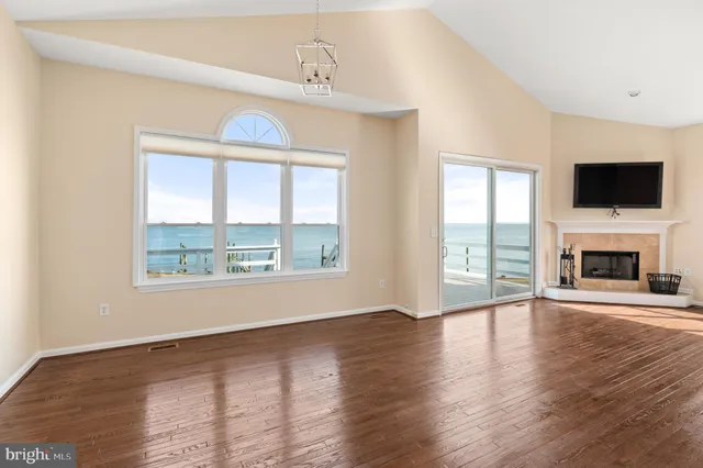 wooden floor fireplace and windows in an empty room