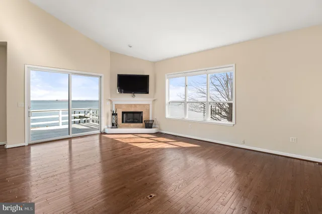 wooden floor fireplace and windows in an empty room