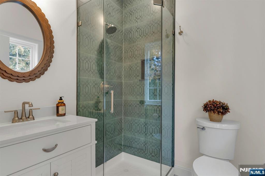 2127 Locust Road Sea Girt, NJ 08750 - Photo 28 of 48 a bathroom with a toilet sink vanity and mirror