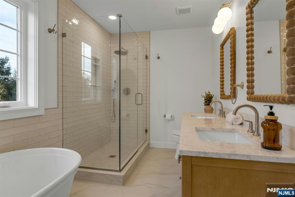 2127 Locust Road Sea Girt, NJ 08750 - Photo 33 of 48 a bathroom with a granite countertop sink a mirror and a bathtub