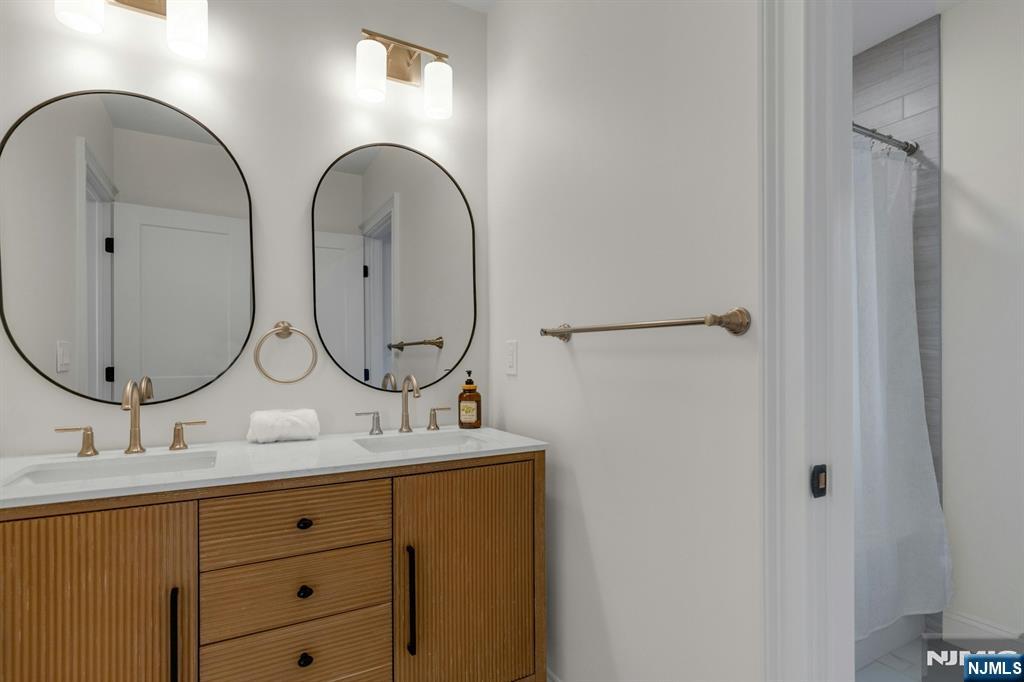 2127 Locust Road Sea Girt, NJ 08750 - Photo 39 of 48 a bathroom with a double vanity sink and a mirror