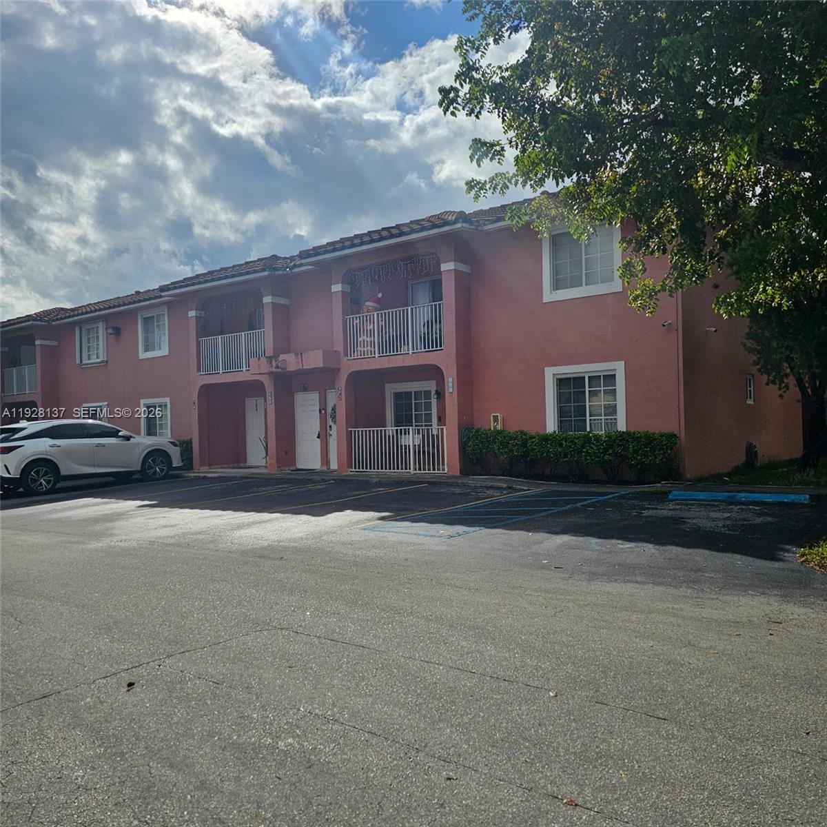 5850 West 18th Lane, Unit 103 Hialeah, FL 33012 - Photo 2 of 4 a front view of a house with a yard