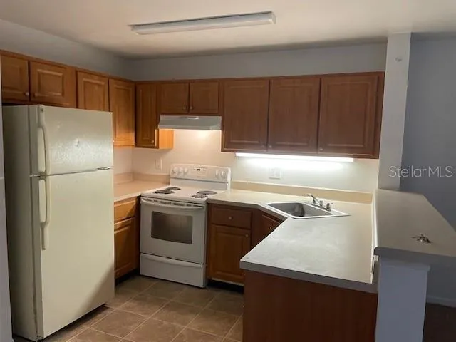 a kitchen with a refrigerator sink and stove