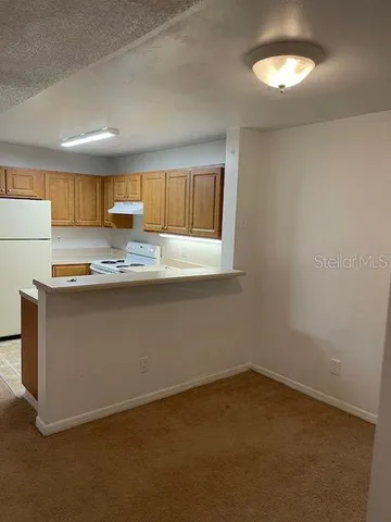 a kitchen with kitchen island a sink a stove a window and a refrigerator