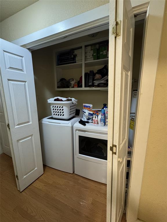636 East Kempner Street Mabank, TX 75147 - Photo 18 of 28 Dedicated laundry area featuring a built-in shelf unit, wood-finish flooring, and bi-fold closet doors