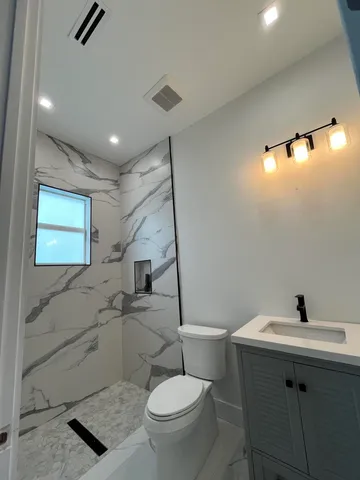 a bathroom with a sink a toilet and mirror